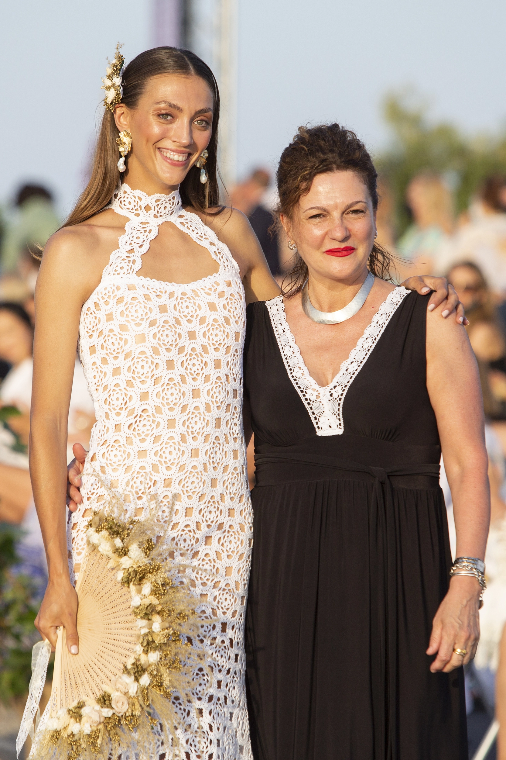 Monika Maxim junto a una modelo con vestido blanco de ganchillo