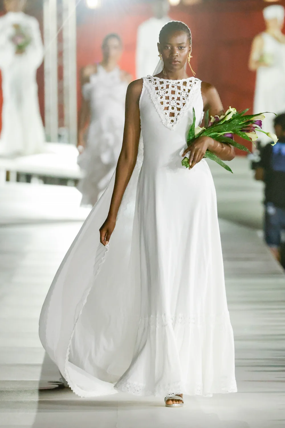 Modelo con vestido largo blanco calado en el desfile de la colección SS 2027